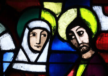 A stained glass image of a woman with Jesus