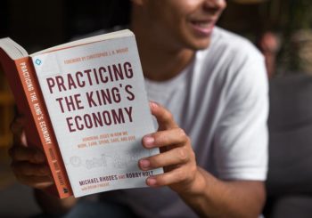 Man holding book "Practicing The King's Economy"
