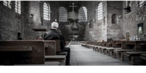Face of a black man overlaid on image of an older man praying in an empty sanctuary