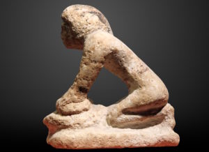 Ancient statue of a woman baking bread