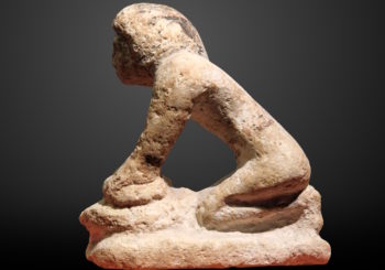Ancient statue of a woman baking bread